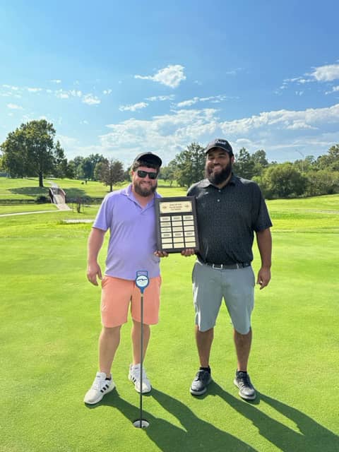 Golfers with celebratory plaque